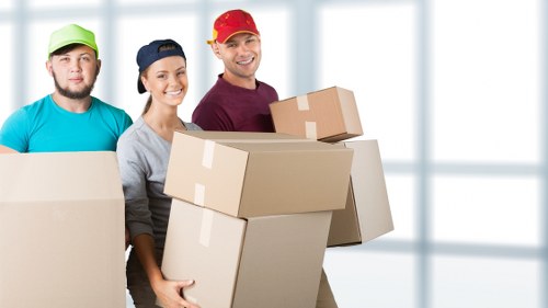 Local movers carrying furniture in a Kennington flat